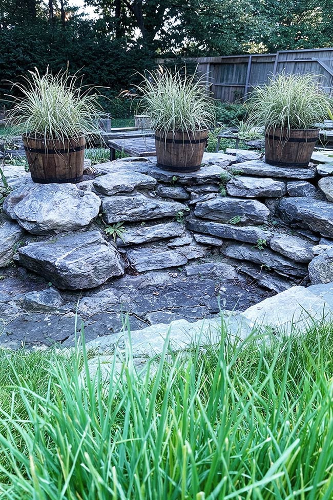 Wooden Barrels and Tiered Stones for a Rustic Rock Garden